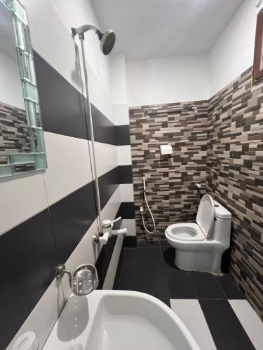 a bathroom with a white toilet and a sink at Karachi Inn PECHS in Karachi