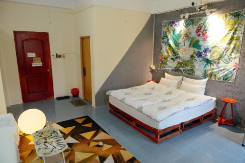 a bedroom with a bed with a painting on the wall at Bụi Homestay - Ferry to Rạch Giá in Rạch Giá