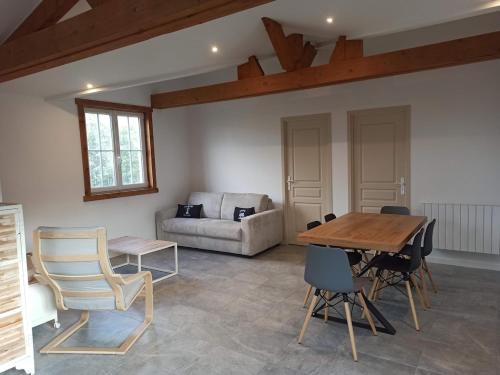 ein Wohnzimmer mit einem Holztisch und Stühlen in der Unterkunft Maison de vacances Ile d'Oléron 2 Chambres in Saint-Pierre-dʼOléron