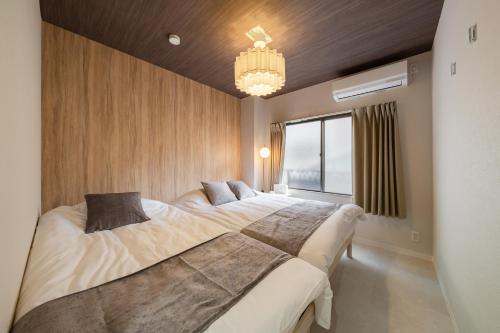 a bedroom with two beds and a chandelier at Lucky you! SHIBUYA in Tokyo