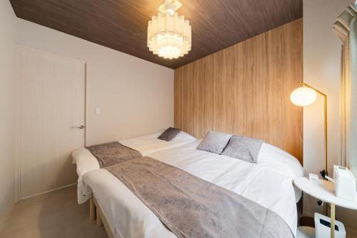 a bedroom with two beds and a chandelier at Lucky you! SHIBUYA in Tokyo