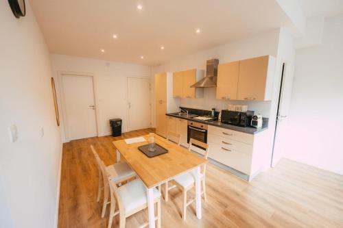 a kitchen and dining room with a wooden table and chairs at Appartement lumineux et calme sur la Route des vins in Guebwiller