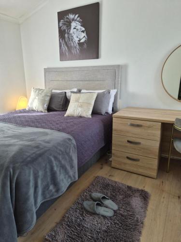 ein Schlafzimmer mit einem Bett, einem Schreibtisch und einem Spiegel in der Unterkunft The Compass in Marina da Gama