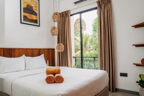 a bedroom with a bed with two towels on it at Riptide Surfhouse in Weligama