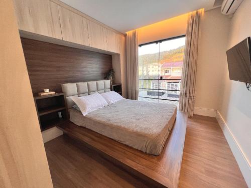 um quarto com uma cama e uma janela grande em Casa com Jacuzzi próximo ao teleférico, aquário, Greenvalley e praia! em Camboriú