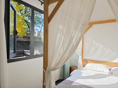 um quarto com uma cama e uma janela em 寺外茶宿SiWai tea&house-Near Xi' an Bell Tower em Xian