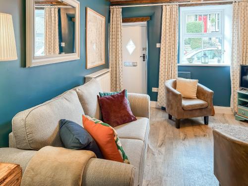 a living room with a couch and a chair at Parsley Cottage in Tideswell