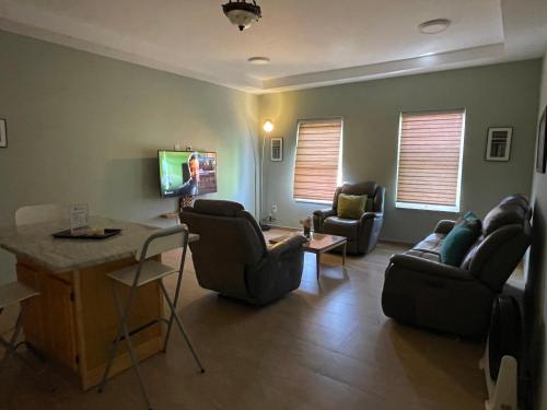a living room with chairs and a couch and a table at Spencer Residencial APARTAMENTOS in Praia