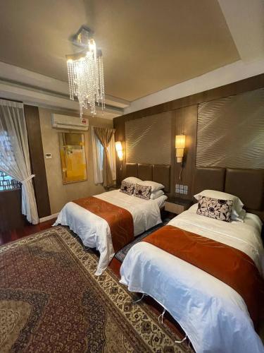 ein Hotelzimmer mit zwei Betten und einem Kronleuchter in der Unterkunft Perhentian Island CorallView Resort - BlueStar in Kampong Pasir Hantu