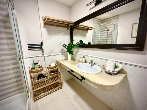 ein Badezimmer mit Waschbecken und Spiegel in der Unterkunft Verano Eterno Balcon del Mar by Deihu Experiences in Arona