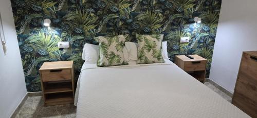 a bedroom with a bed with a floral wallpaper at Apartamento Cozy Inns Playa in Torremolinos