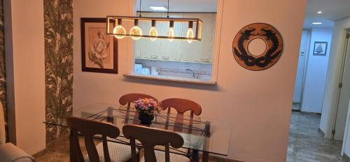 a dining room with a table with chairs and a mirror at Apartamento Cozy Inns Playa in Torremolinos