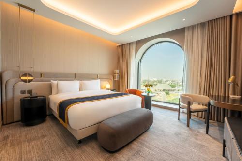 a hotel room with a bed and a large window at MOVENPICK HOTEL AL ZAYTOON BAGHDAD in Baghdad