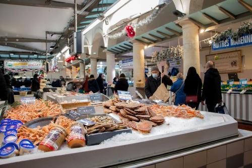 Menschen, die auf einem Markt mit ausgestellten Meeresfrüchten herumlaufen in der Unterkunft République 5 - Downtown & close to thermal baths in Rochefort