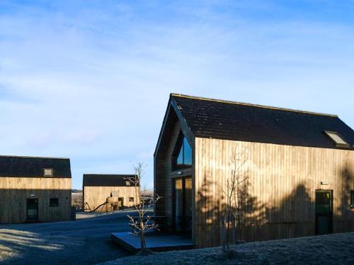 a wooden barn with a tree in front of it at Bothy 2 - Uk50472 in Greenhaugh