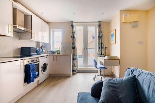 a living room with a couch and a kitchen at The Burleigh palace in Cambridge