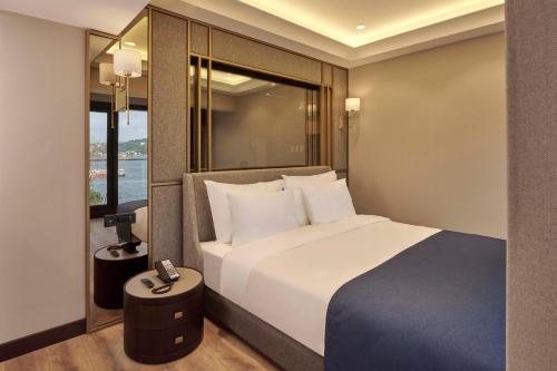 a hotel room with a bed and a window at Çırağan Hotel Bosphorus in Istanbul