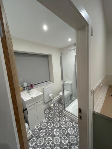 a bathroom with a toilet and a sink and a shower at Cosy Corner Cheadle in Cheadle