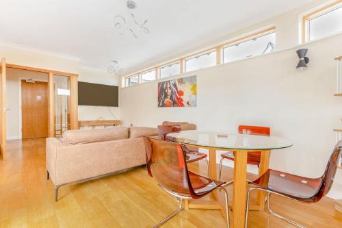 a living room with a table and a couch at The Cambridge Penthouse in Cambridge