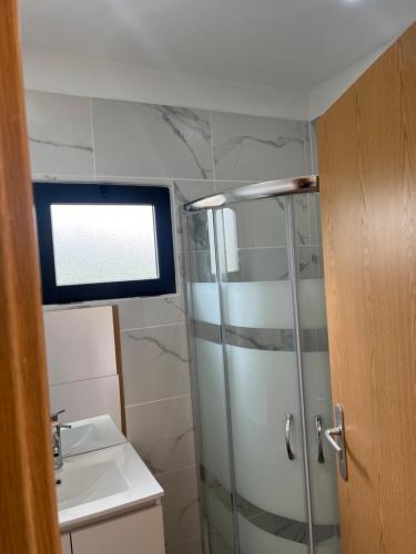 a bathroom with a shower and a sink at Casinha do codecal in Labruja