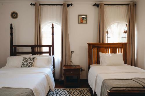 ein Schlafzimmer mit zwei Betten und einem Fenster in der Unterkunft Naibor Villa in Themi