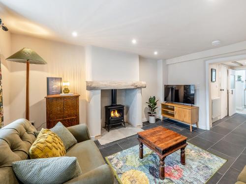 a living room with a couch and a fireplace at The Cottage At Number One in Caerwys