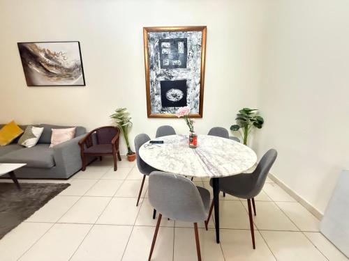 a living room with a table and chairs and a couch at Lavender Oasis - Entire Spacious 1 flat in Jumeirah Village Circle in Dubai