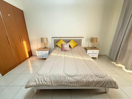 a bedroom with a large bed with two night stands at Lavender Oasis - Entire Spacious 1 flat in Jumeirah Village Circle in Dubai