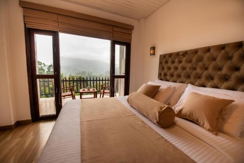 a bedroom with a large bed with a large window at Zircon Ella in Ella