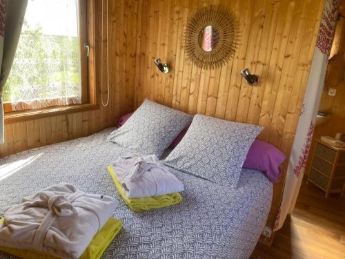 ein Schlafzimmer mit einem Bett mit Handtüchern darauf in der Unterkunft Roulotte au domaine du Bouygues in Salvagnac-Cajarc