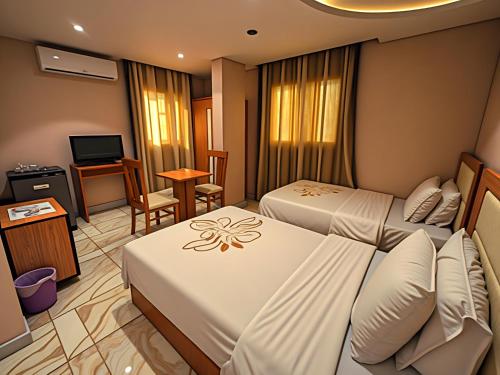 a hotel room with two beds and a television at Pyramids & SphinX Grand Hotel in Cairo