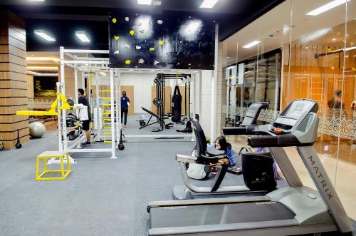 a gym with tread machines and people in it at Tara Hotel Yogyakarta in Yogyakarta