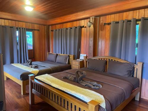 Ban Song (1)にあるบ้านสวนเปรมณัฐตราのぬいぐるみが置かれたベッドが2つある寝室