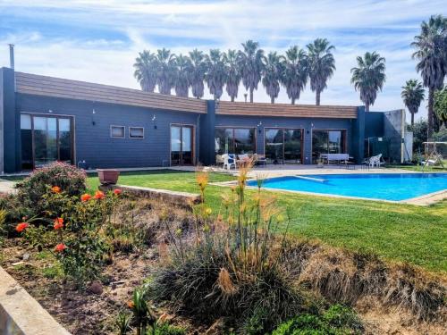 une maison avec une piscine et des palmiers dans l'établissement Casa Limache,5 dormitorios, 6 baños, piscina cancha, 