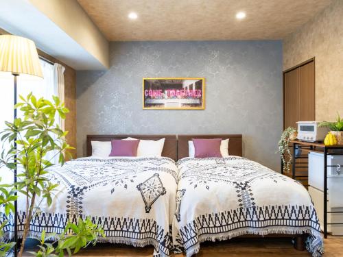 a bedroom with two beds and a wall at MY STORY Classic 405-瓦町駅徒歩6分 in Shimminatomachi