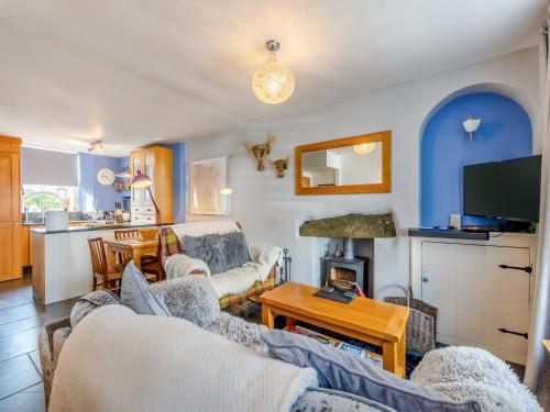 ein Wohnzimmer mit zwei Sofas und einem Fernseher in der Unterkunft Slate Cottage in Windermere