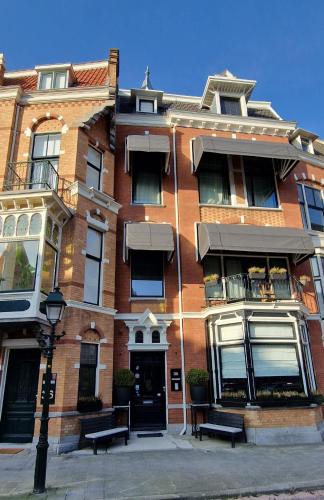 a brick building with two benches in front of it at Residenz Stadslogement in The Hague