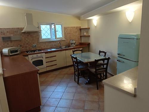 a kitchen with a table and chairs and a refrigerator at Casa Mille Lire in Ciampino