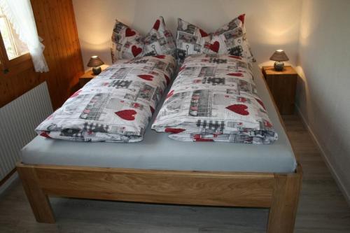 a bed with a comforter and pillows on it at Fewo Mit Herz in Horboden