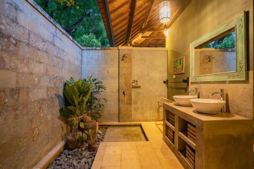 een badkamer met twee wastafels en een douche bij Villa Bukit Kaja Kauh in Pemuteran