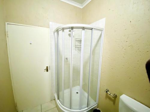 a shower with a glass door in a bathroom at Sandton Skyline Suite - 2 Bedroom Apartment in Sandton