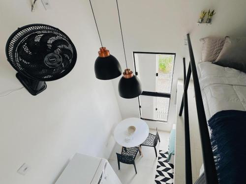 Un dormitorio con una cama, una mesa y un espejo. en Loft Aconchegante & bem localizado II, en Santo Antônio dos Prazeres