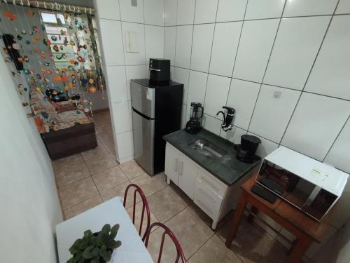 une petite cuisine avec un évier et un réfrigérateur dans l'établissement Casa em Tiradentes, à Tiradentes