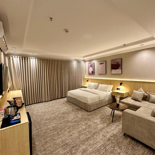 a hotel room with two beds and a couch at نسيم الحرم 2 in Ash Shishah