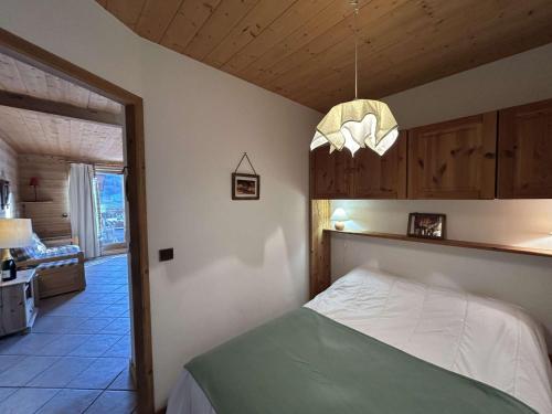 a bedroom with a bed and a chandelier at Appartement cosy 2 pièces avec wifi à Méribel - FR-1-180-663 in Chandon