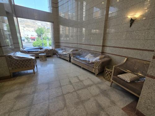 Zimmer mit mehreren Betten und einem großen Fenster in der Unterkunft فندق مهوى الفؤاد - المعابدة in An Naqāʼ