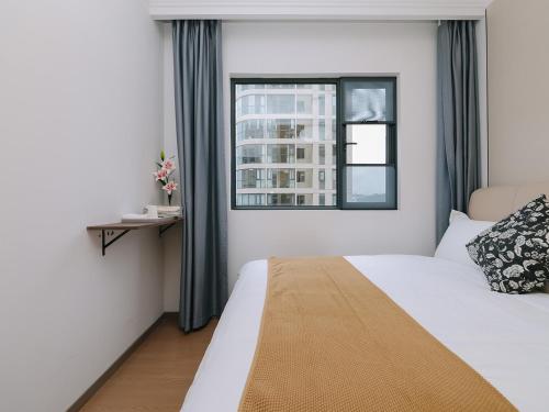 a hotel room with a bed and a window at Annie Apartment 2105 in Kunming
