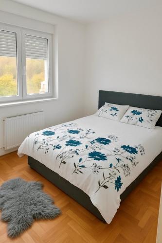 Un dormitorio con una cama con una manta azul y blanca. en Apartman Kalina, en Belgrado