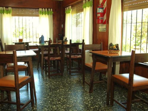een eetkamer met tafels en stoelen en ramen bij LalomitaGesell in Villa Gesell