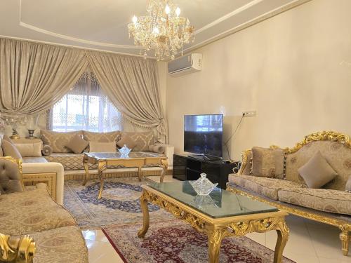 sala de estar con muebles y lámpara de araña. en Beach View Appartement, en Tánger